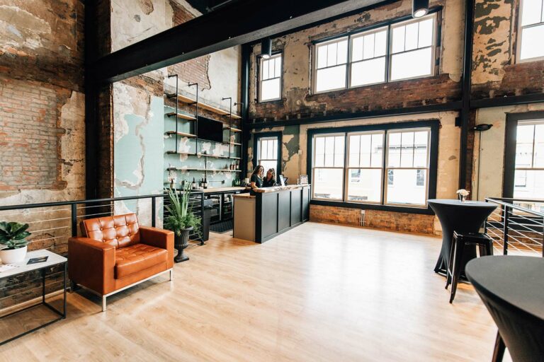 Open loft space with large windows and chairs.