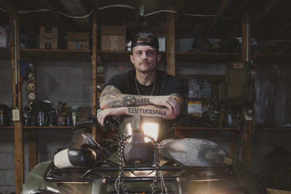 Man with tattoos in a garage on a 4-wheeler